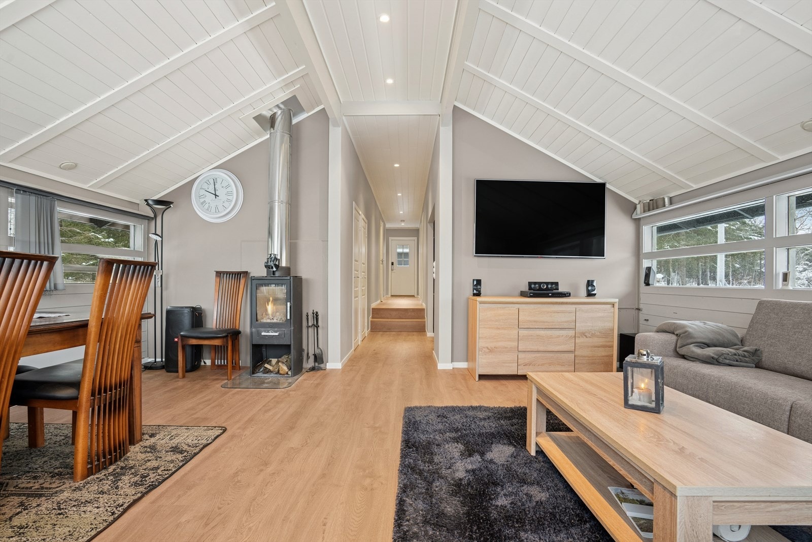 Stuen byr på romslig plass til både en komfortabel sofagruppe og et innbydende spisebord, perfekt for både avslapning og hyggelige måltider. Galleribilde