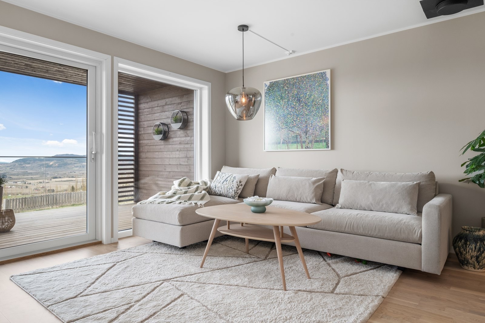 Den åpne stuen har store vinduer som fyller rommet med naturlig lys gjennom hele dagen. Fra stuen er det utgang til en 15 kvm stor, takoverbygd balkong/veranda med gode solforhold og flott panoramautsikt mot landlige omgivelser. Galleribilde