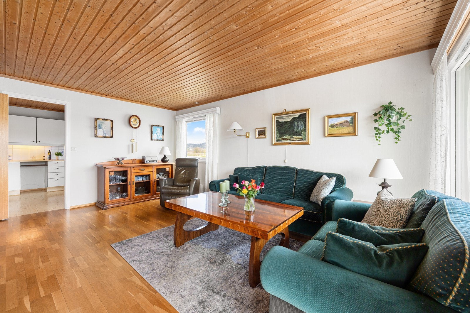 Rommet har plass til en romslig sofagruppe og har gjennomgående trepanel i himlingen. Galleribilde