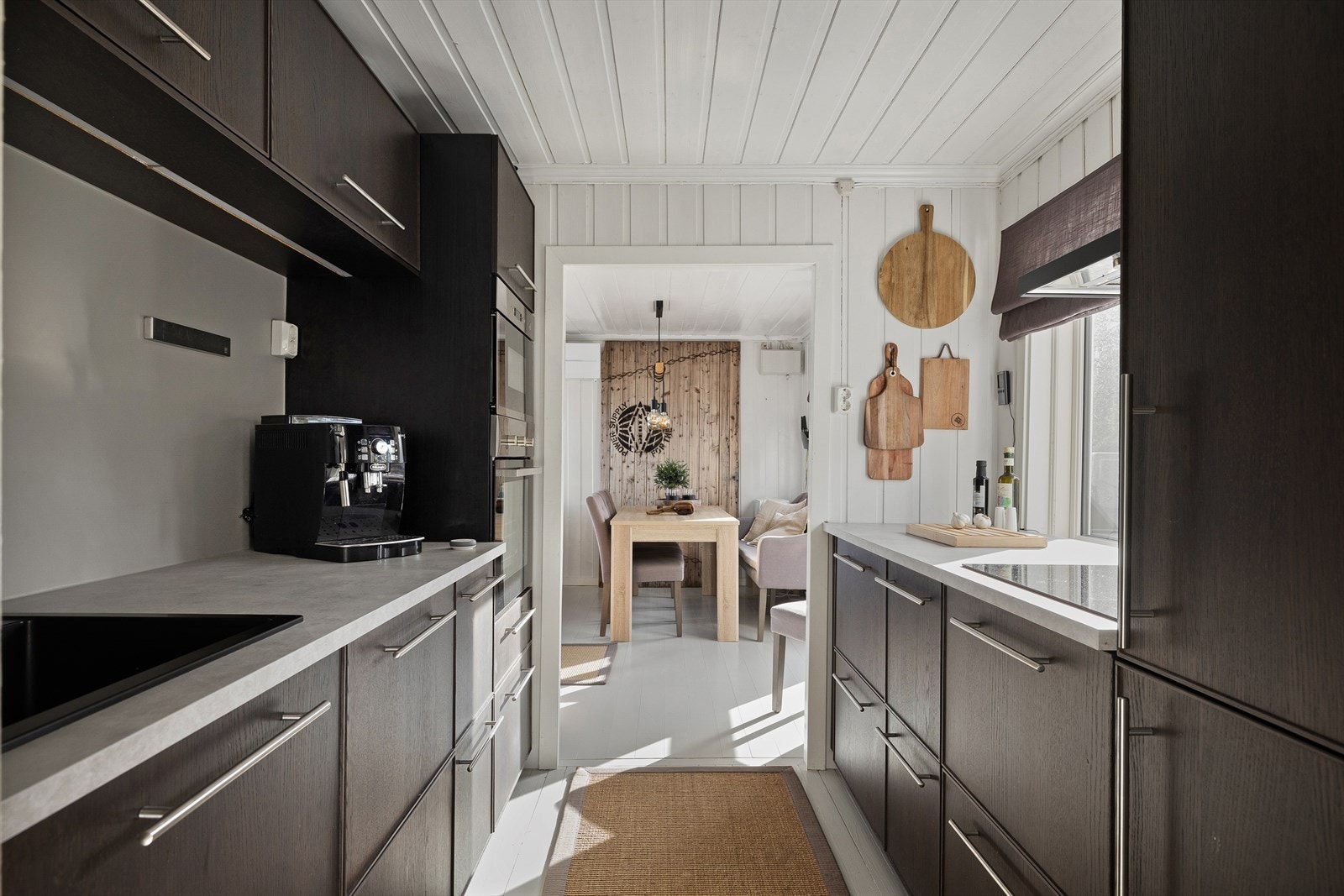 Kjøkkenet har døråpning til spisestuen. Det ble pusset opp i 2019 med innredning fra IKEA _ mørkebrune trefronter og steinmønstret benkeplate. Velutstyrt _ med stekeovn, mikrobølgeovn og komfyr. Galleribilde
