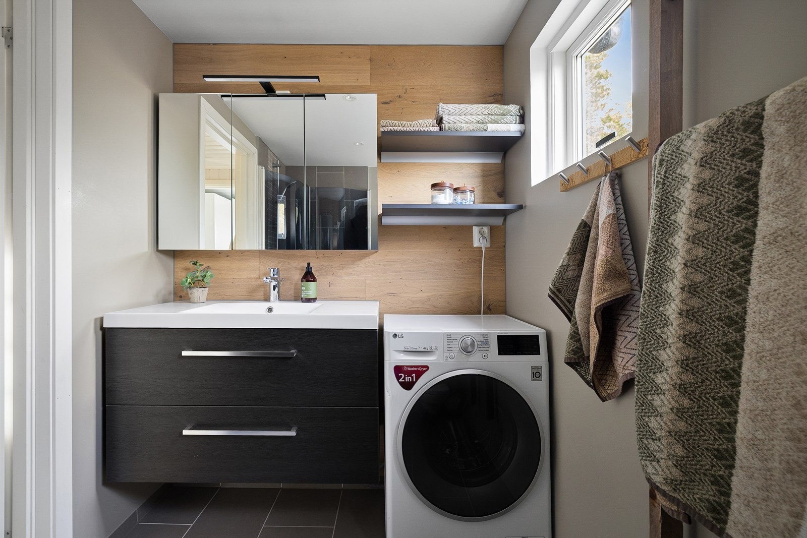 Badet har varmekabler i gulvet og en moderne, flislagt dusjsone. Rommet ble pusset opp i 2020 og har et pent og oppdatert uttrykk. Her er det tilrettelagt plass til vaskemaskin. Galleribilde