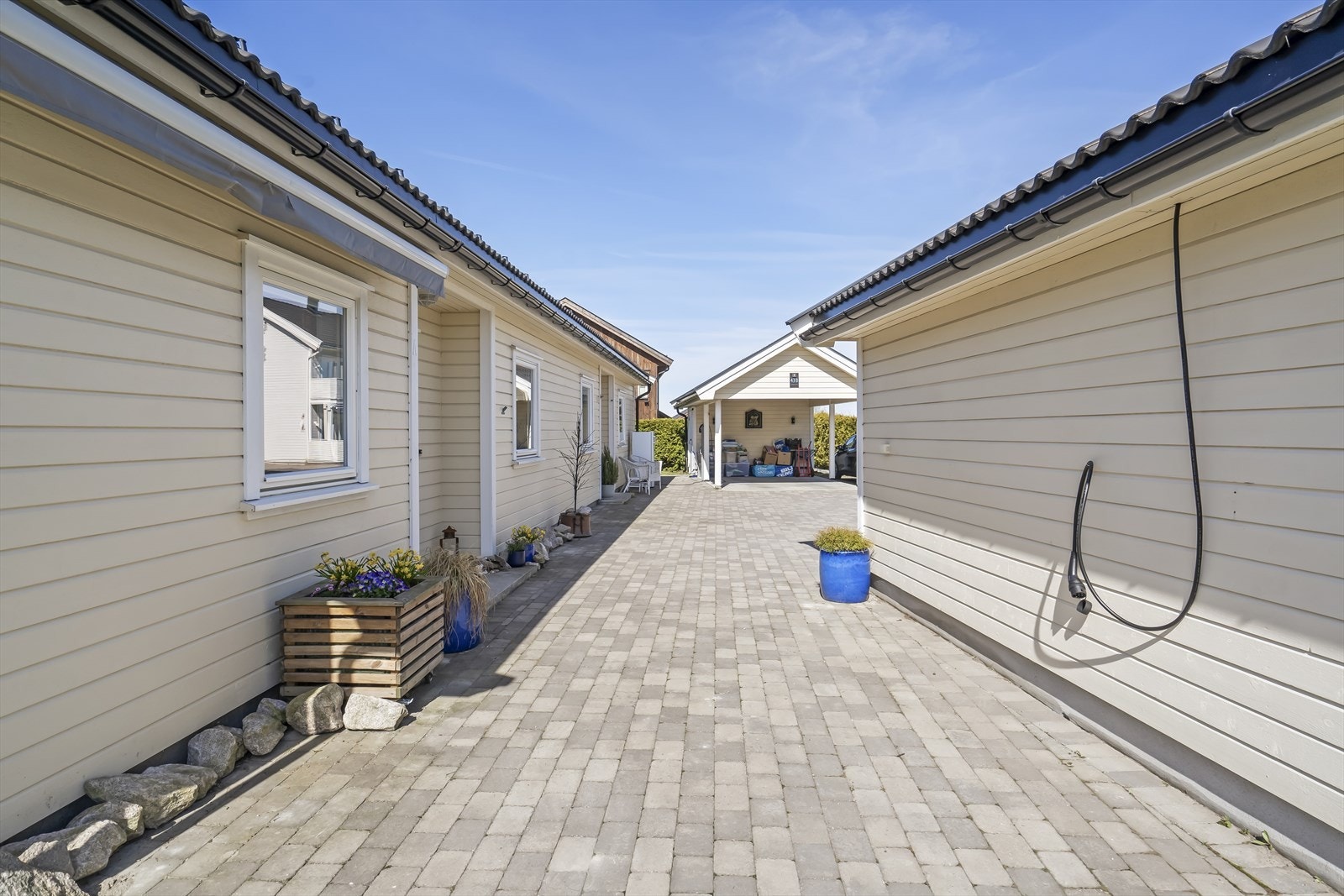 Gårdsplassen har belegningsstein og leder inn til boligen og garasjen. Galleribilde