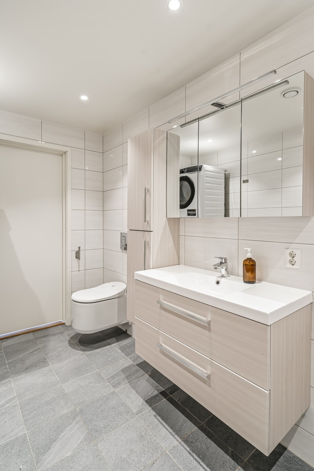 Badet har vegghengt toalett og er klargjort med opplegg for vaskemaskin. Galleribilde