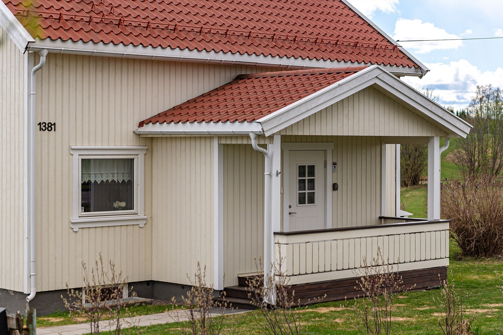 Overbygget inngangsparti med heller på gangsti fra gårdsplassen. Galleribilde