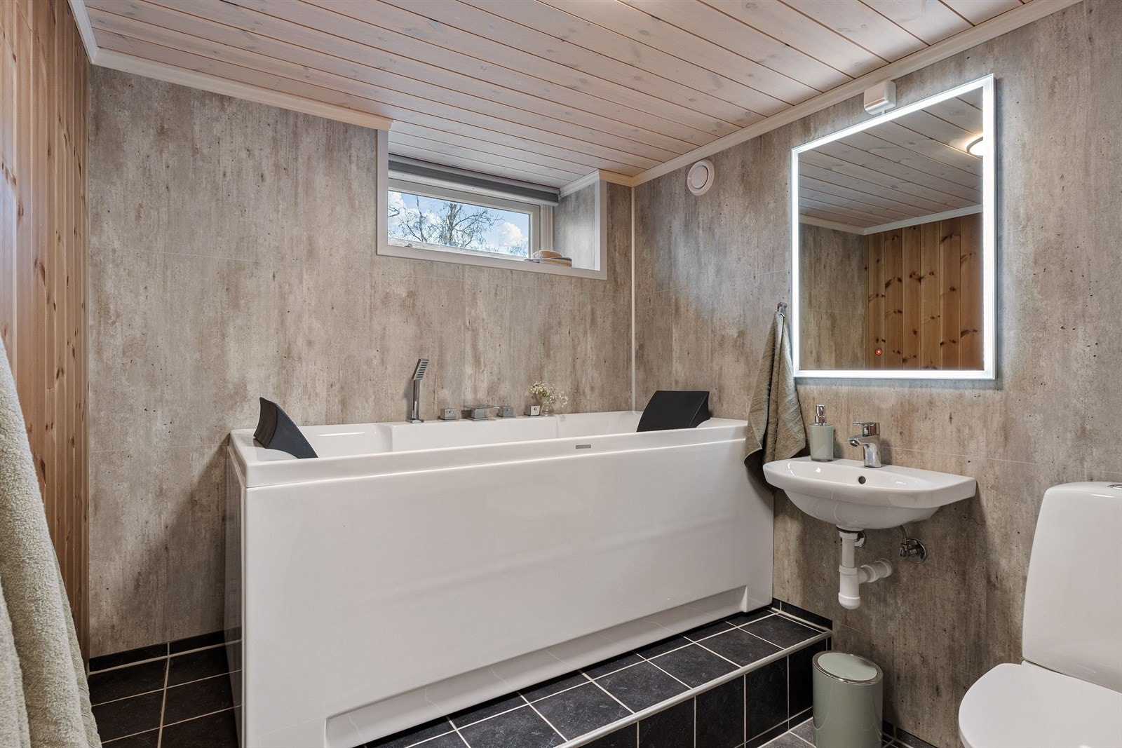 Bad i kjeller med badekar, servant og toalett. Galleribilde