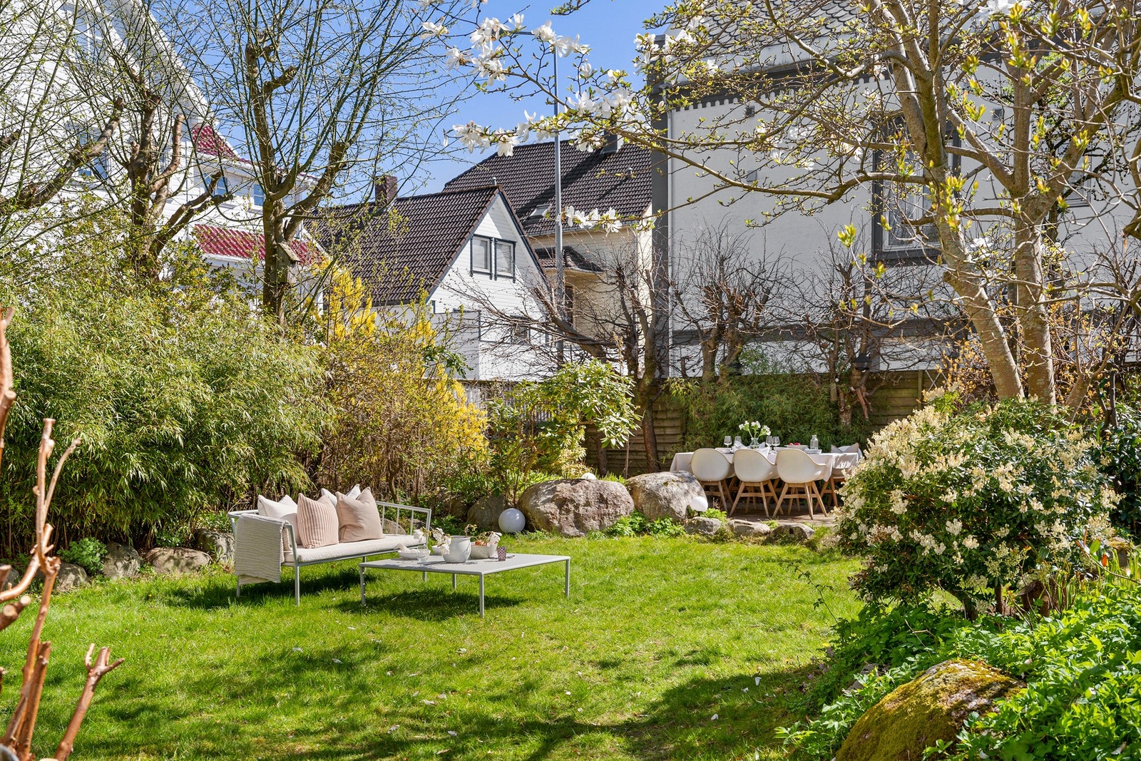 Hagen er pent opparbeidet med plen og beplantning bestående av blant annet epletrær, stikkelsbær og bringebær, noe som gir en frodig og hyggelig ramme rundt boligen. Galleribilde