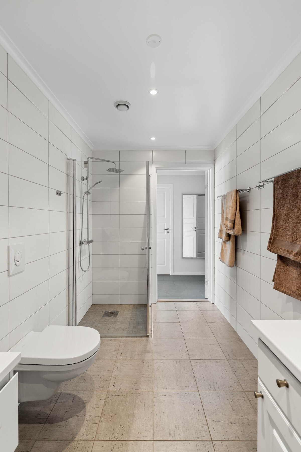 Badet har en tidløs utførelse som gir et rent og ryddig uttrykk.. Opplegg for vaskemaskin og tørketrommel Galleribilde