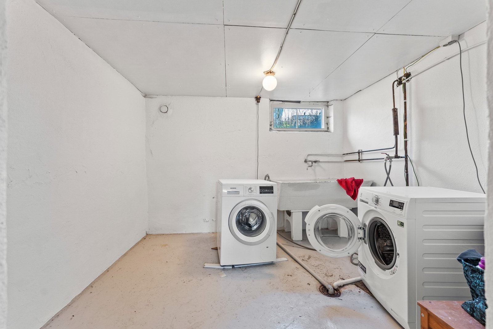 Separat vaskerom i kjeller med opplegg for vaskemaskin og utslagsvask. Galleribilde