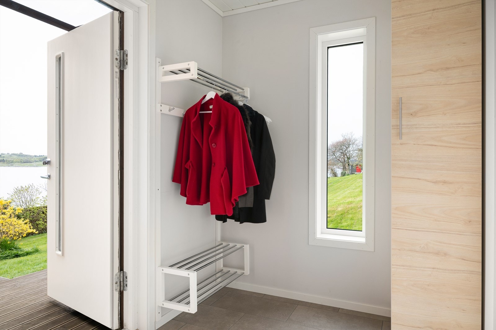 Entré med moderne detaljer, praktiske oppbevaringsløsninger og gjennomført materialvalg. Galleribilde