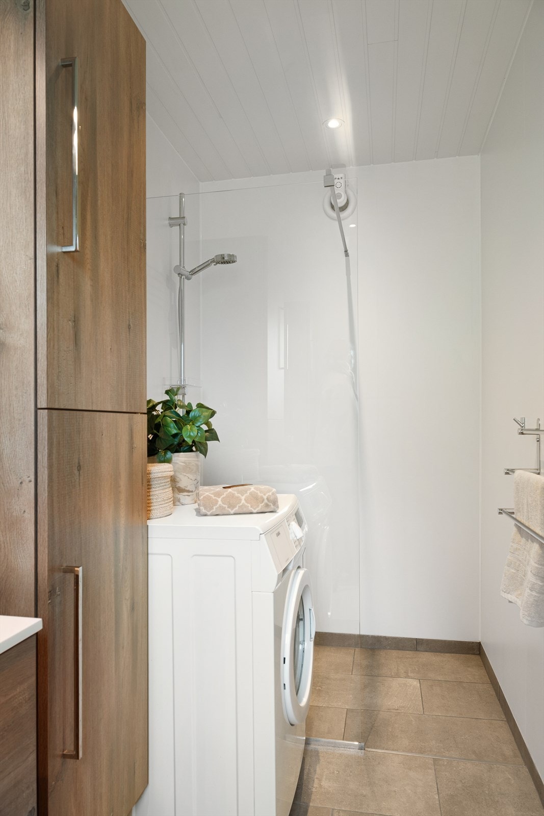 Badet er utstyrt med praktisk dusjløsning og stilrene overflater i lyse toner. Galleribilde
