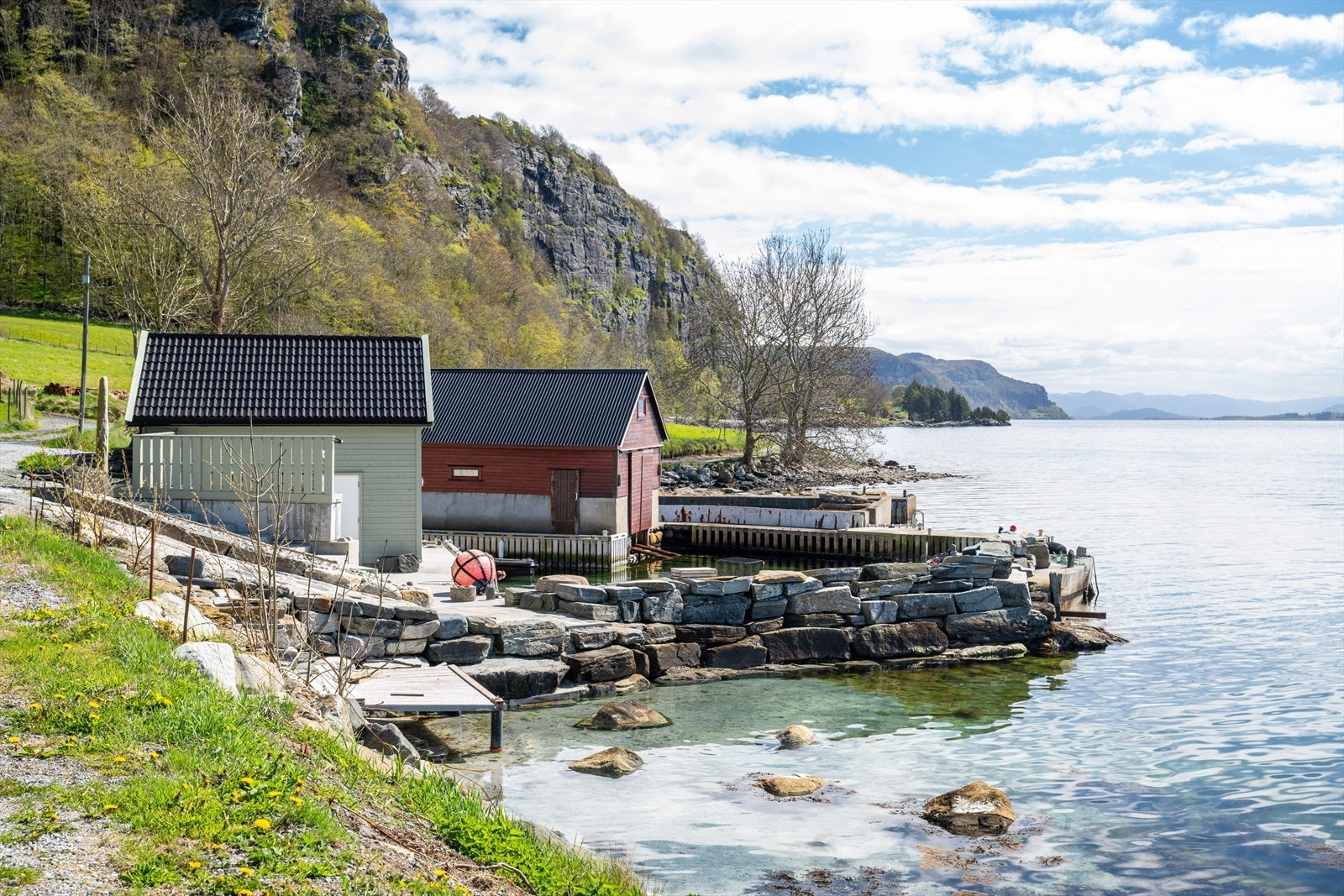 Sjølinjen byr på flotte omgivelser med naust, bryggeanlegg og badestrand. Galleribilde