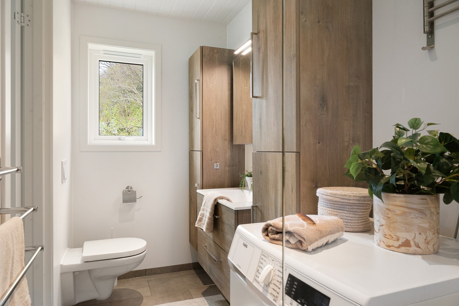 Delikat bad med moderne innredning, opplegg for vaskemaskin og gode oppbevaringsmuligheter. Galleribilde