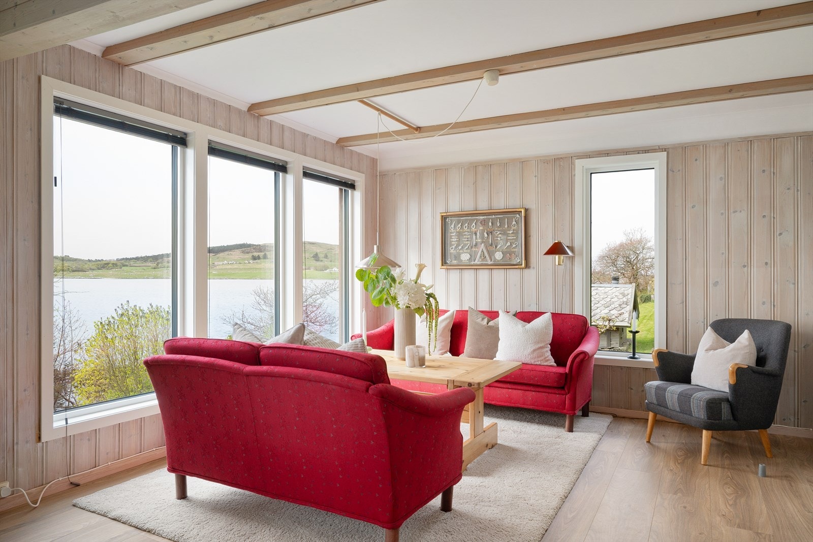 Lys og innbydende stue med store vindusflater som rammer inn den vakre utsikten mot fjorden. Galleribilde