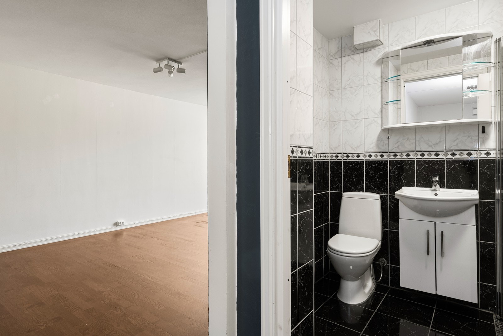Badet er innredet med servant på skap og gulvstående toalett. Galleribilde