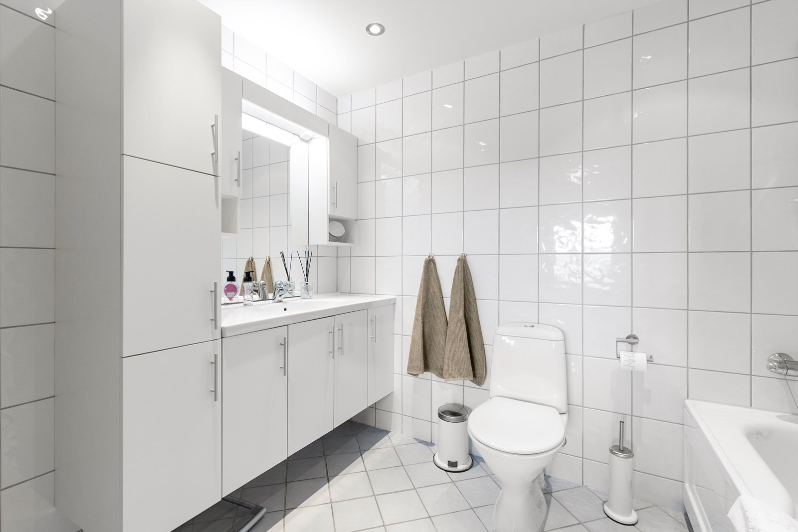 Hovedbadet er flislagt og innredet med servantskap, toalett og badekar. Galleribilde