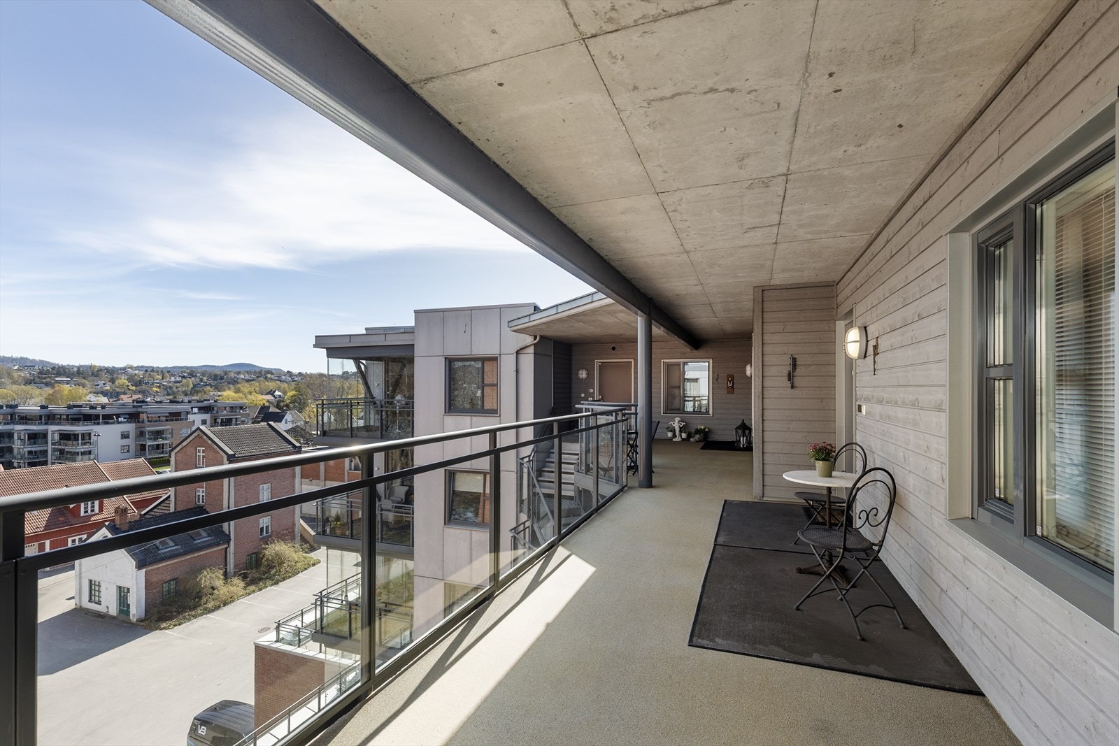 En lys og åpen svalgang fører frem til inngangsdøren. Galleribilde