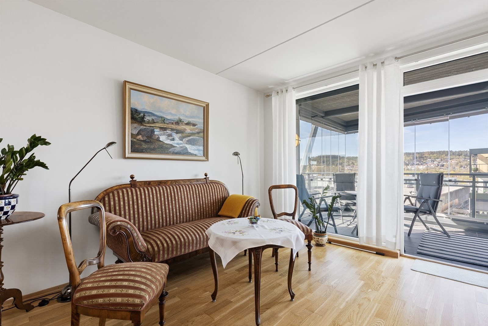 Store glassflater og dør mot balkongen slipper rikelig med dagslys inn i stuen. Galleribilde
