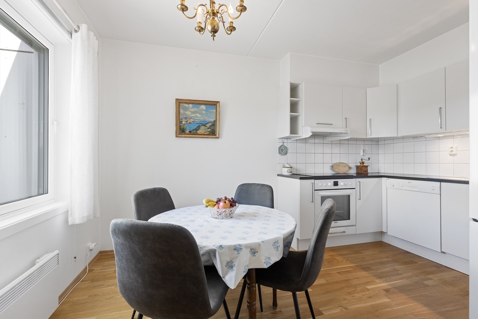 Kjøkkenet er utstyrt med integrert komfyr, mekanisk avtrekksvifte og fliser over benken. Galleribilde