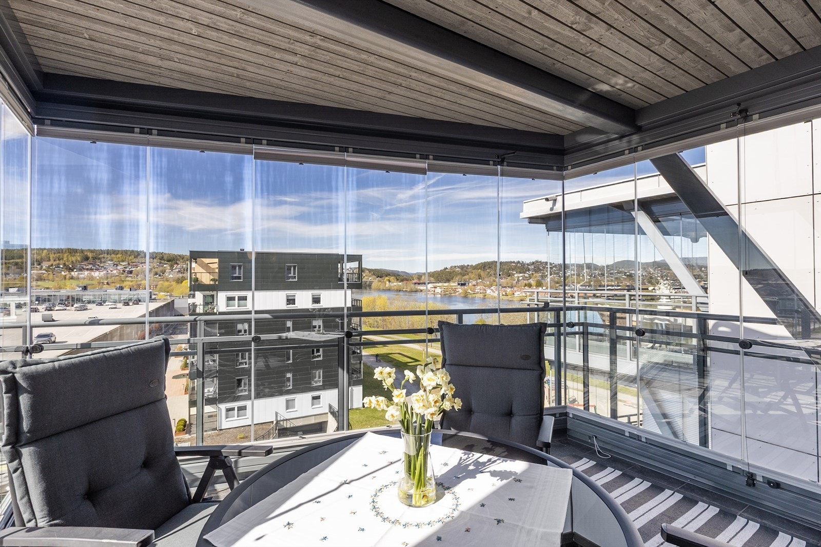 Den innglassede balkongen fungerer som en forlengelse av stuen og gir en lun uteplass med utsikt mot Hjellevannet. Galleribilde