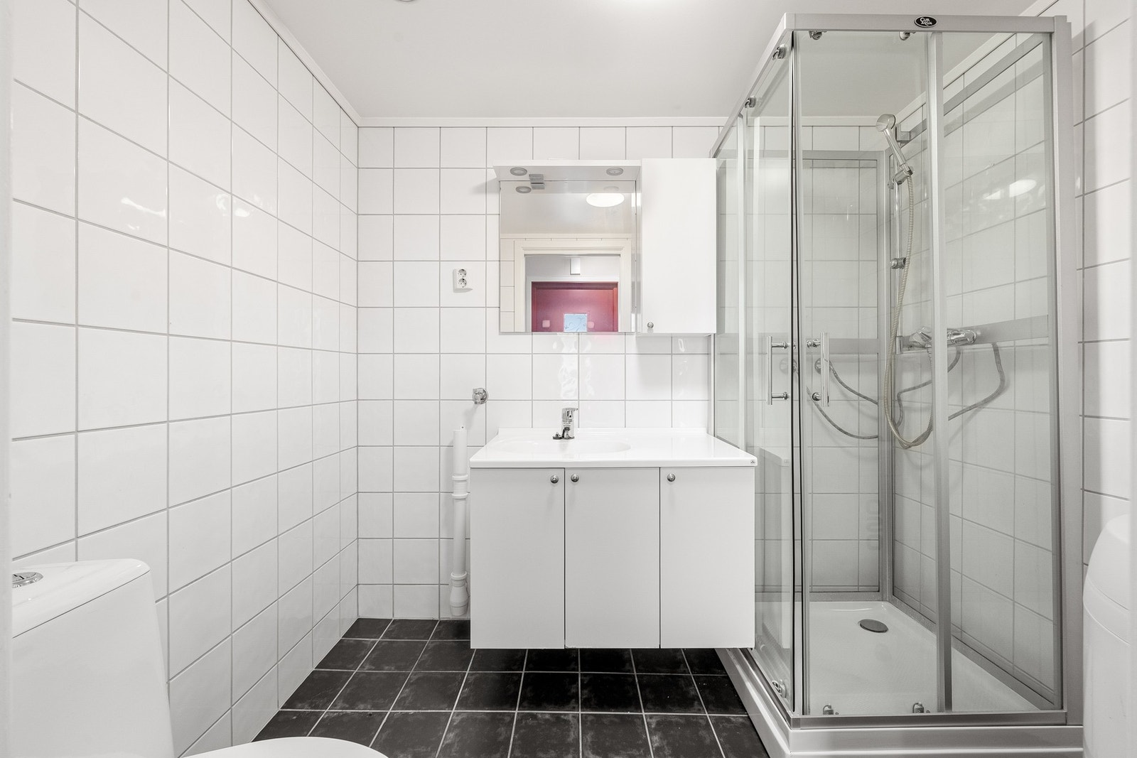 Pent baderom med bereder, dusjkabinett, servant, servantskap, wc og opplegg for vaskemaskin. Galleribilde