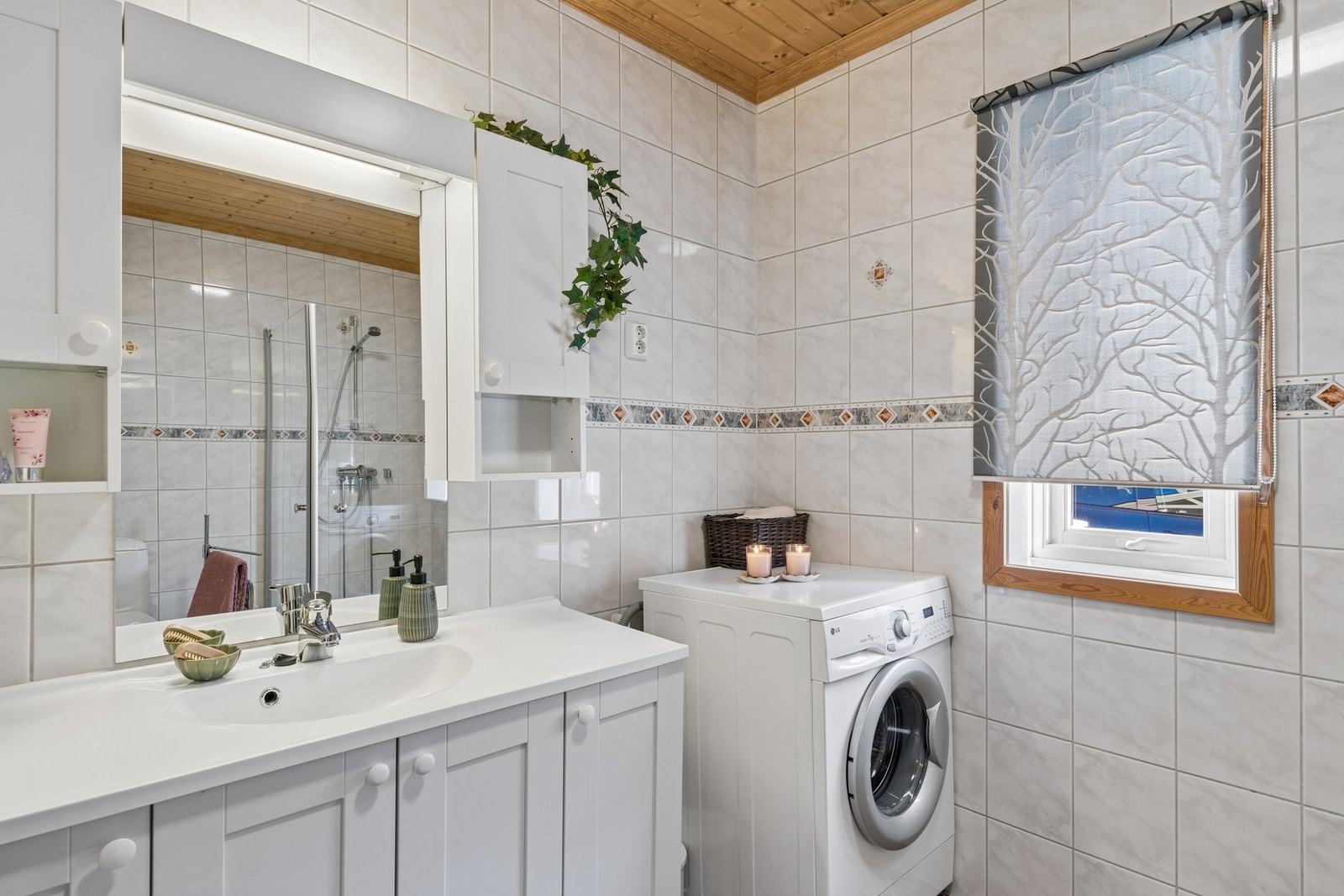 Badet i 1. etasje er et våtrom kombinert med vaskerom. Det har støpt gulv med varmekabler og helflisede overflater på både gulv og vegger. Galleribilde