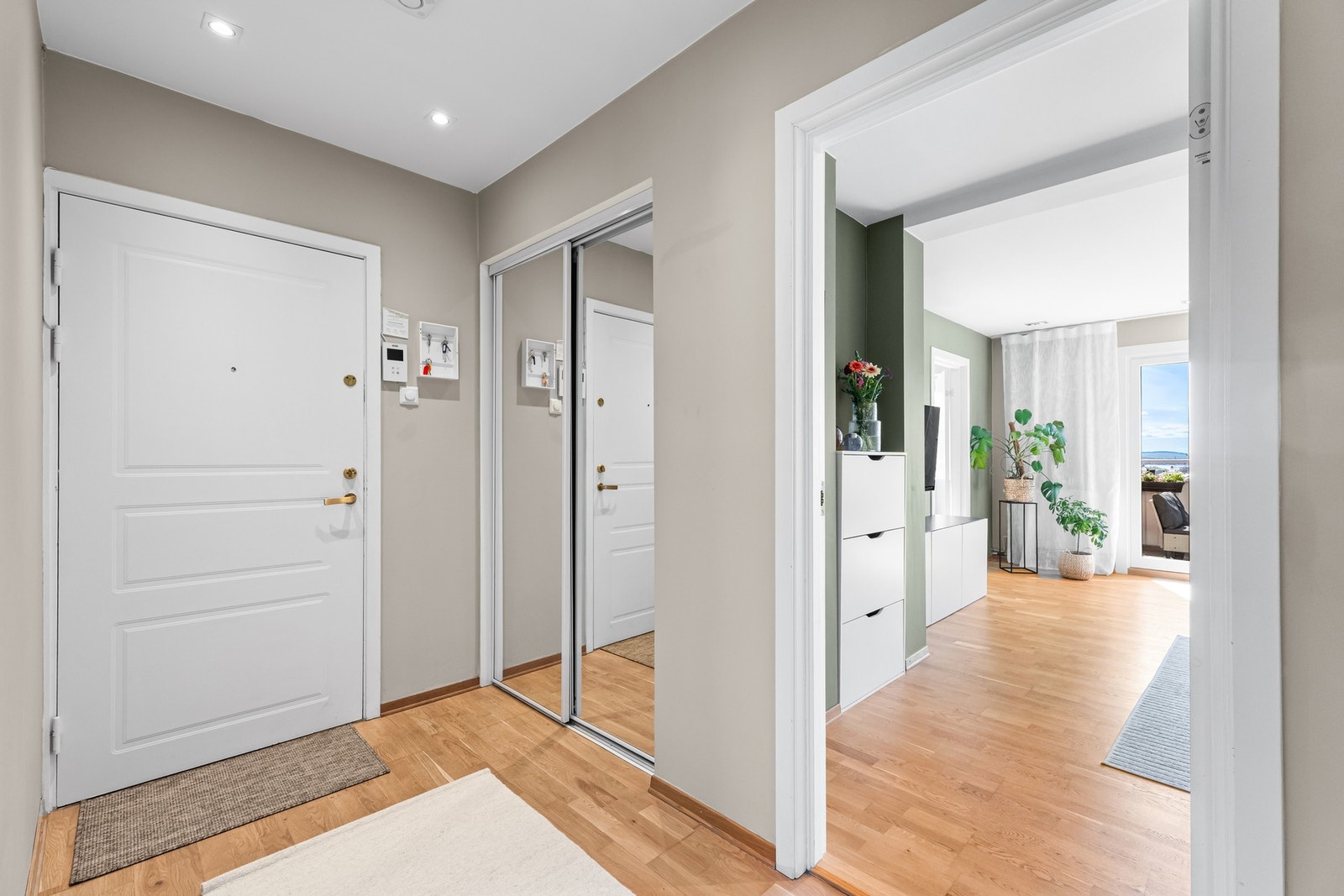 Romslig entré med god plass til avheng av yttertøy og sko i skyvedørsgarderobe med speilfronter. Galleribilde