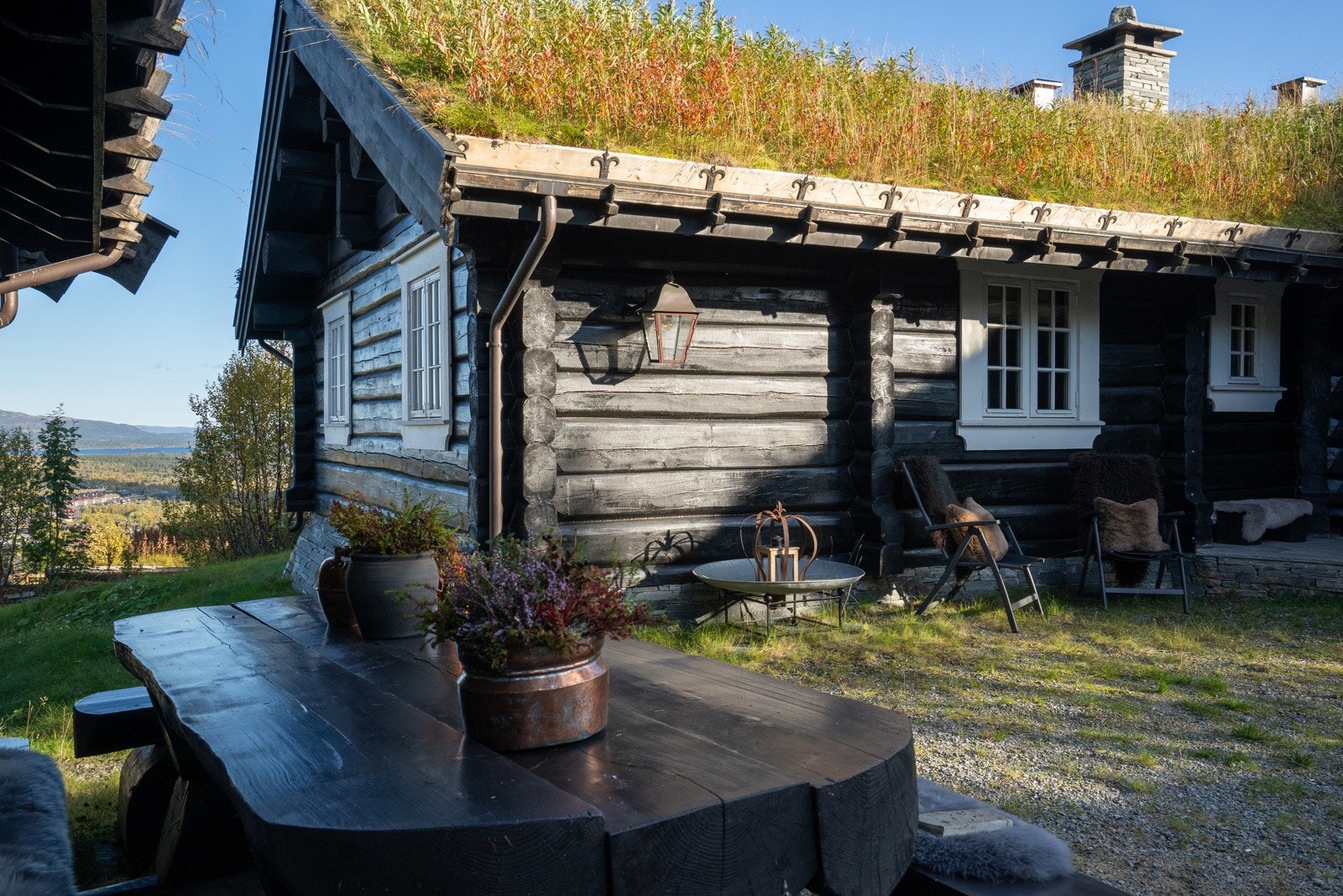 Mellom hytta og annekset er det en nydelig, usjenert plass. Til høyre ser man litt av det representative inngangspartiet med skiferbelagt platting, takoverbygg og flotte søyler. Galleribilde