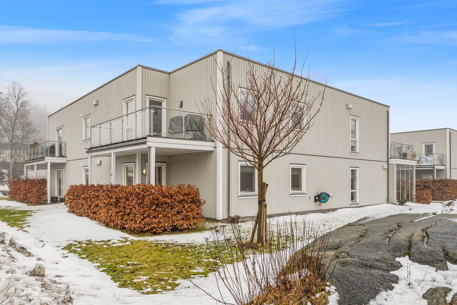 Pent opparbeidede fellesarealer med asfalterte parkeringsplasser, plenarealer og diverse beplantning. Galleribilde