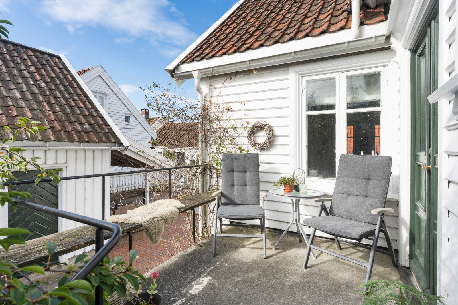 Inngangspartiet på siden av boligen har støpt trapp og platting med plass til sittegruppe som er usjenert og skjermet. Galleribilde