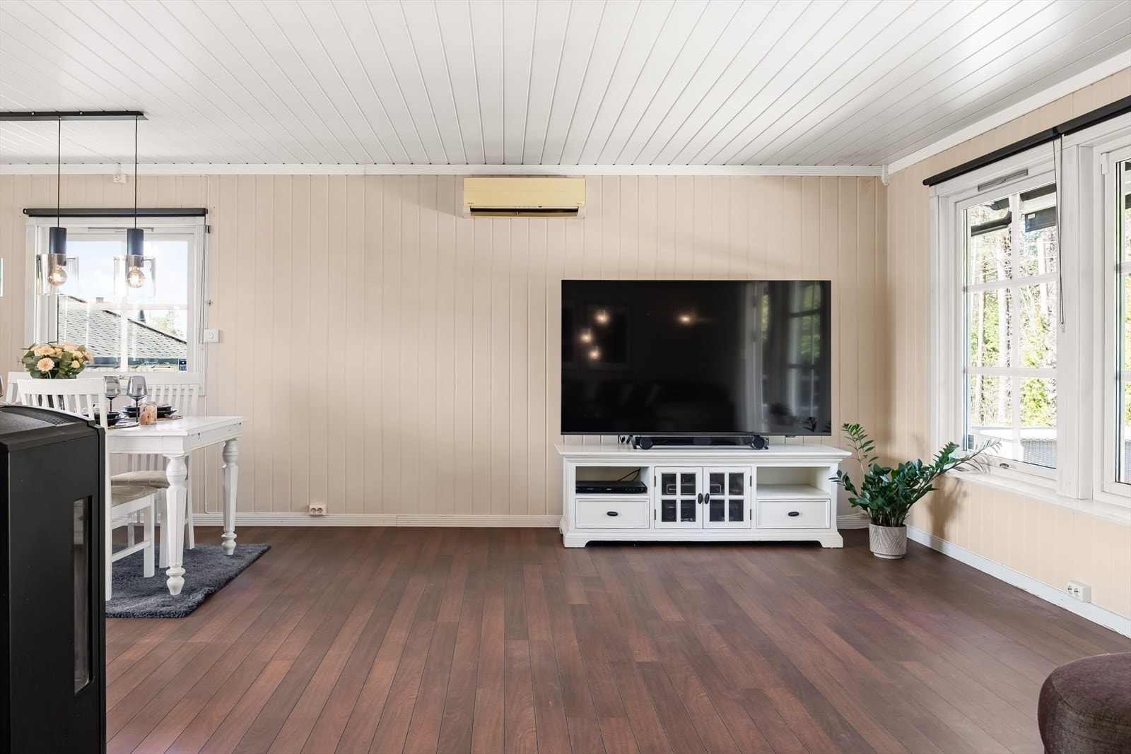 Stor og møbleringsvennlig stue med plater på veggene og laminatgulv. Varmepumpe montert i stuen. Galleribilde