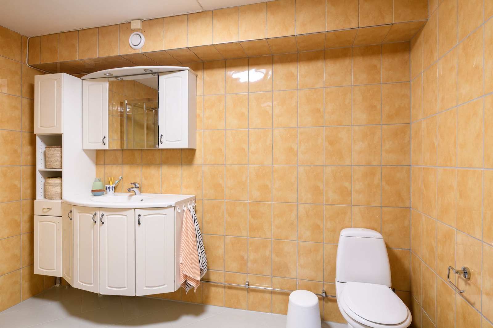 Badet med gulvvarme, toalett, hvit servantinnredning og nyere dusjkabinett fra 2020 Galleribilde