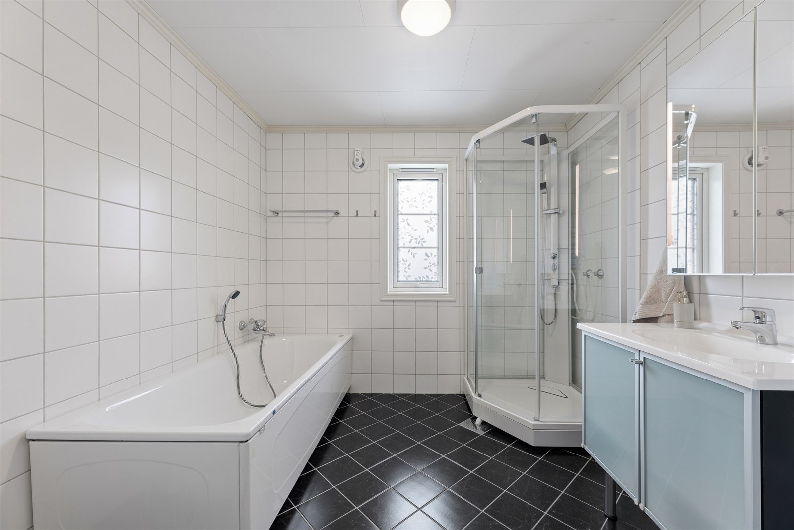 Flislagt bad med innredning fra 2016. Her er det både badekar og dusjkabinett. Galleribilde