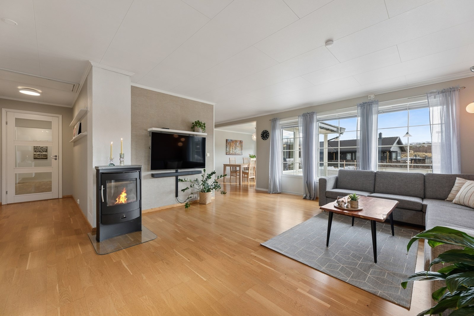 Stuen er et lyst og samlende rom med plass til flere sittegrupper. Vedovnen gir ekstra varme og hygge. Galleribilde