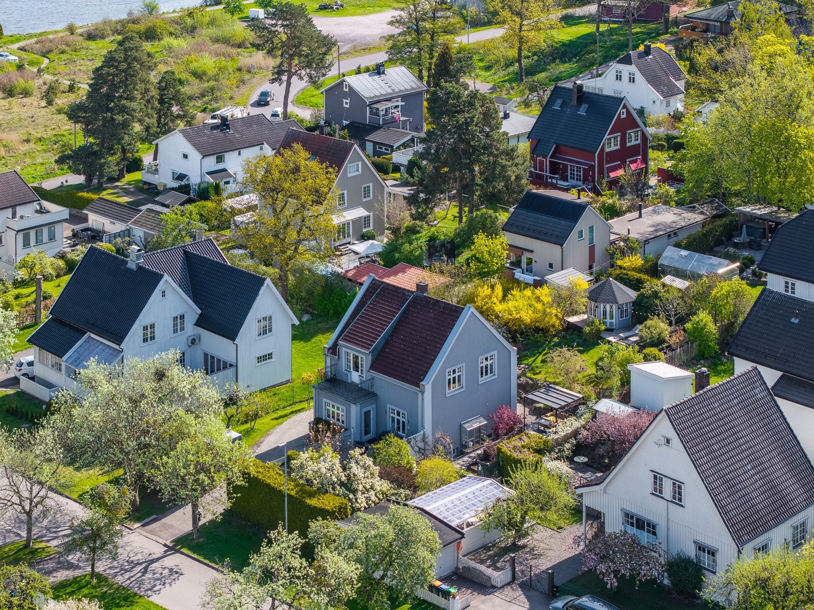 Dronebilde med huset i midten og fjorden oppe til venstre Galleribilde