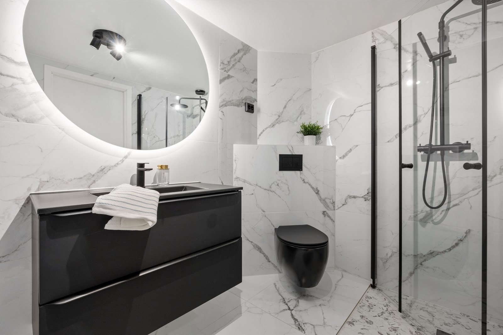 Badet er ellers innredet med dusjhjørne med innfellbare dører, vegghengt toalett, baderomsinnredning med nedfelt servant, speil med varme og varmtvannsbereder. I tillegg har man opplegg for vaskemaskin og plass til tørketrommel. Galleribilde