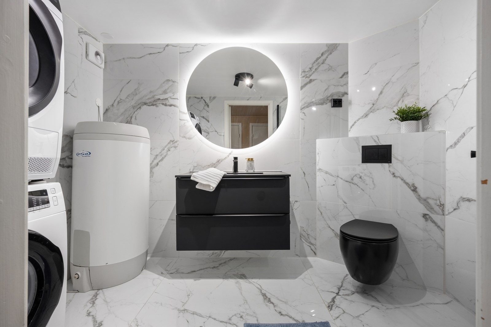 Badet ble oppgradert i årsskiftet 2023 og er lekkert innredet med store, lyse, sjatterte fliser på gulv og vegger. Også her har man varmekabler i gulvet. Galleribilde