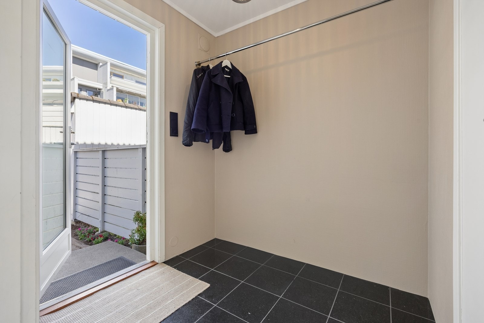 Man ønskes velkommen inn i en romslig entré som er praktisk innredet med flislagt gulv og varmekabler. Her har man god plass til å henge fra seg yttertøy og sko. Galleribilde