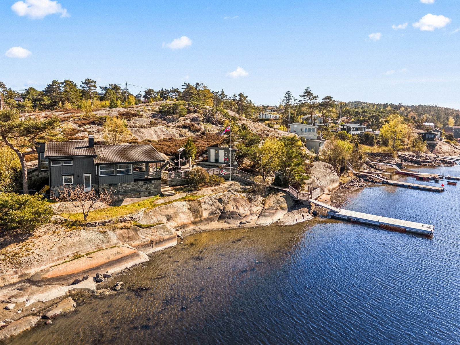 Hytta har en fin arkitektur og plassering på tomta.
Båten ligger fortøyd på egen brygge like nedenfor. Galleribilde