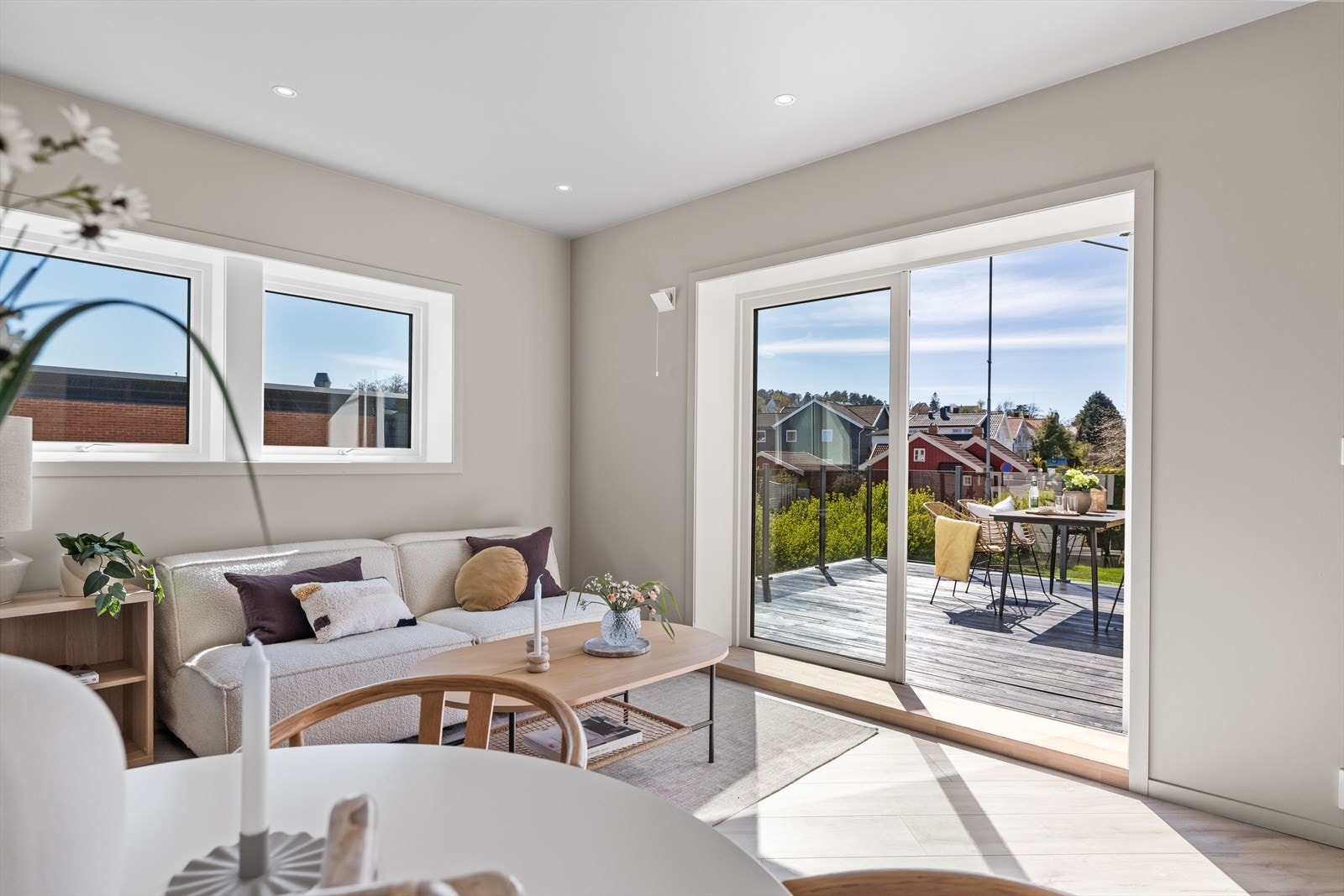 Fra stuen åpner en elegant tofløyet dør opp mot en romslig treterrasse med stilrent glassrekkverk, som gir et luftig uttrykk og gode solforhold. Foto: Paul Skahjem Thürmer Galleribilde