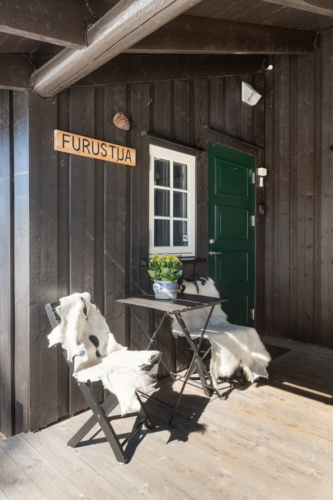 Overbygget inngangsparti med en malt hovedytterdør fra 2012. Galleribilde
