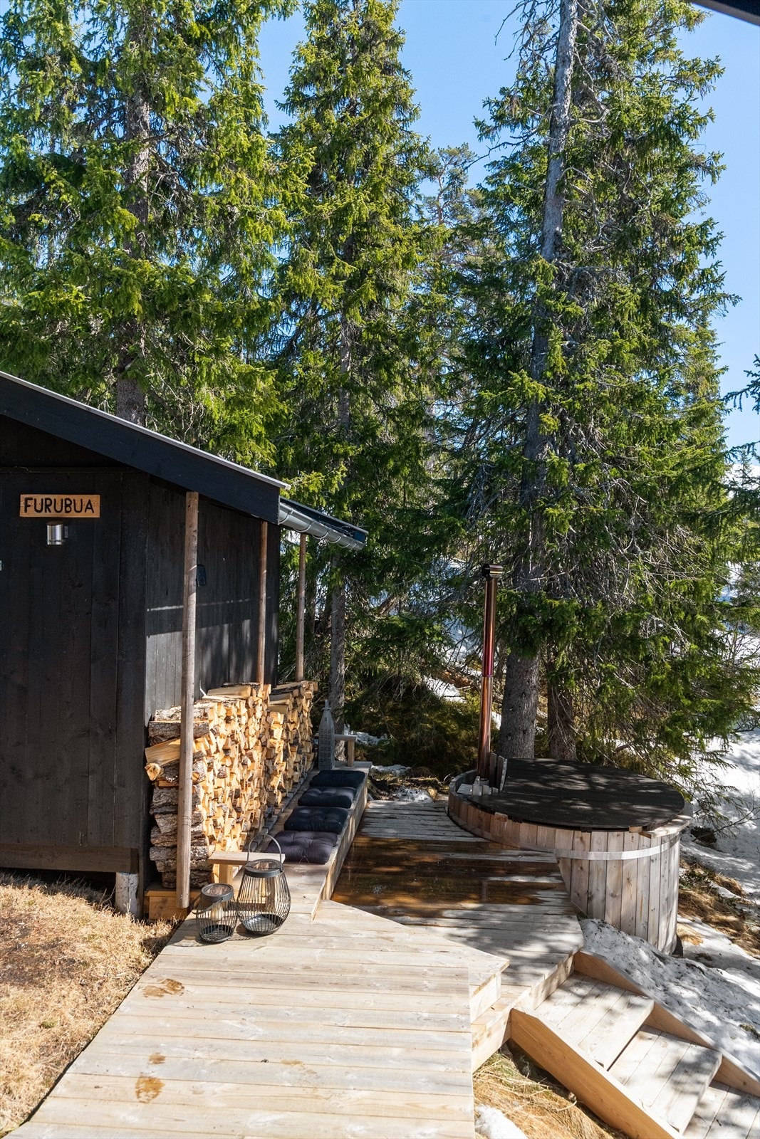 I tilknytning til inngangspartiet er det laget terrasse mot den utvendige boden hvor det er tillaget en hyggelig uteplass med sittebenk og badestamp. Galleribilde