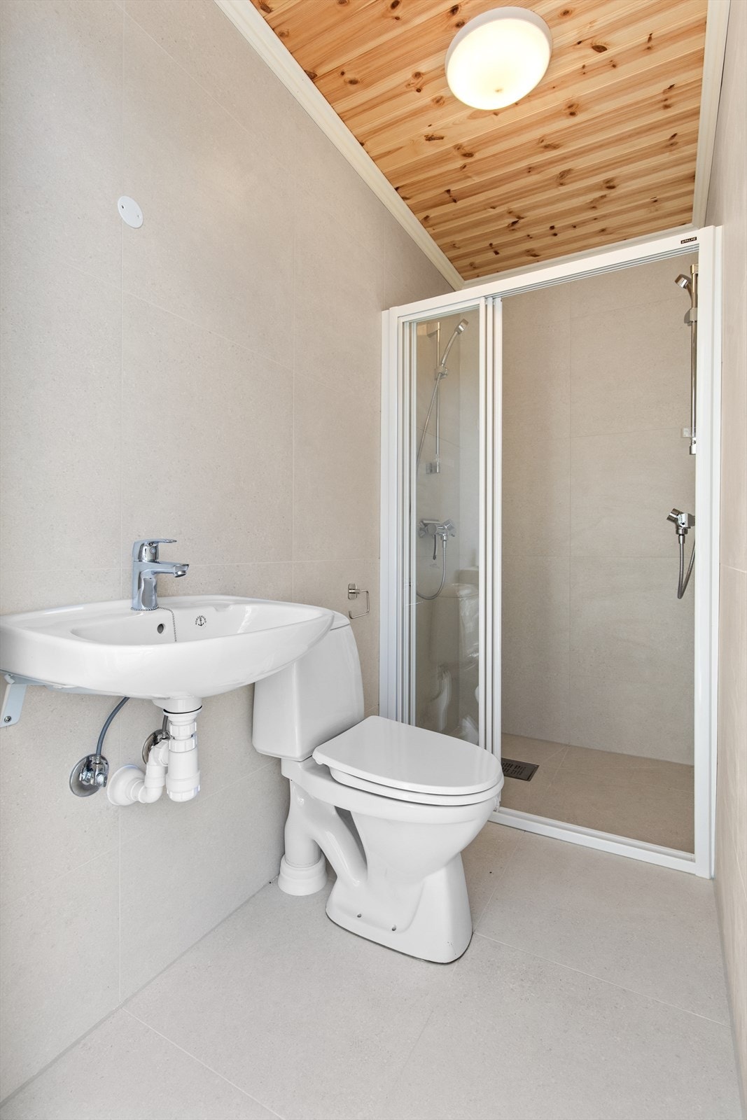 Baderom med adkomst fra terrassen. Badet er innredet med servant, dusj og toalett Galleribilde