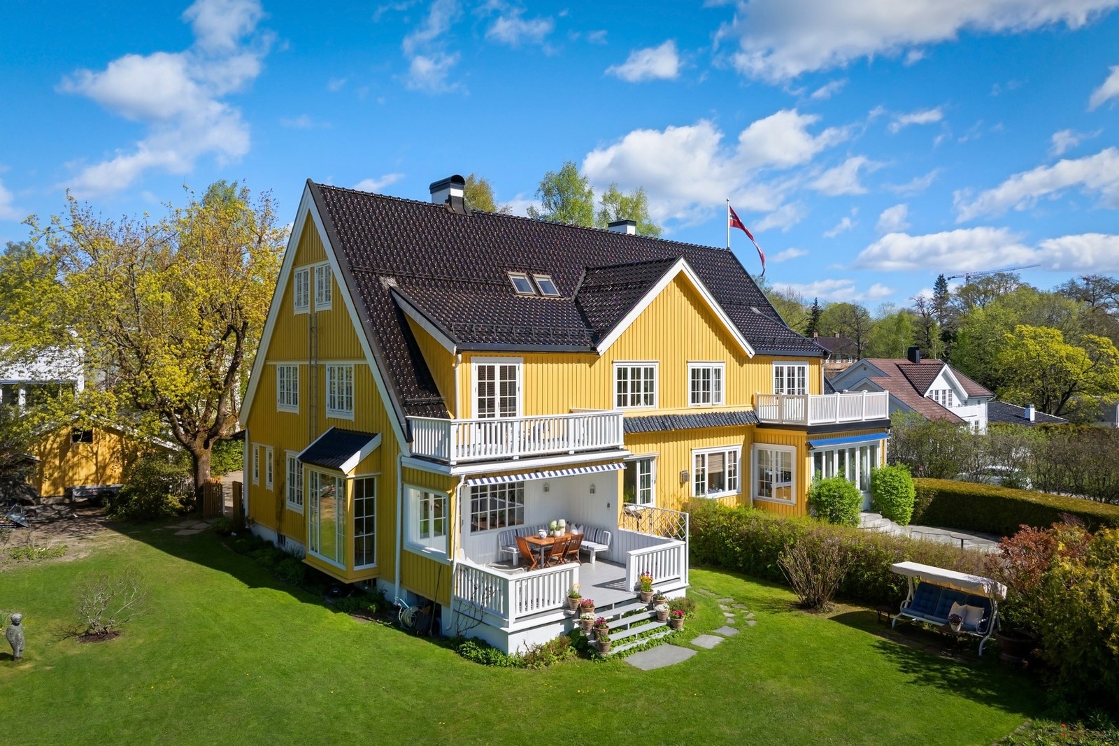 Villaen har et klassisk og tidløst uttrykk med vakker, gul fasade og hvite detaljer. Taket på huset og garasjen ble tekket om med glasert takstein i 2021. Galleribilde