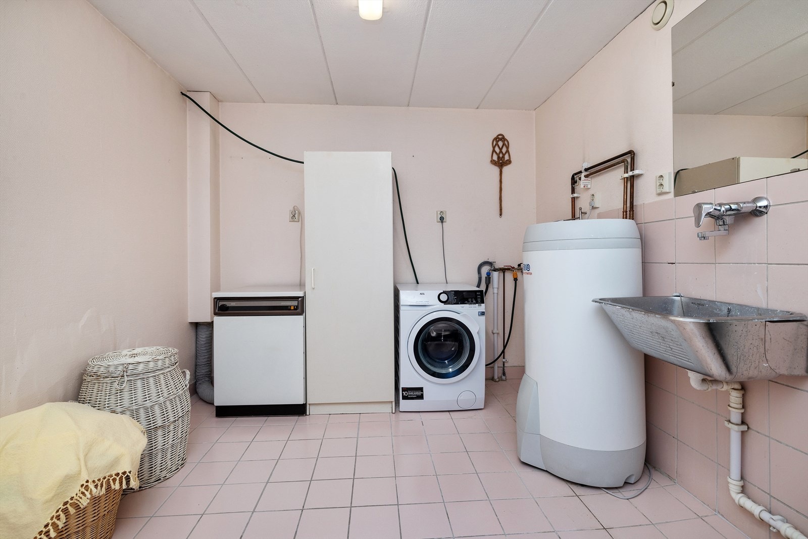 Separat vaskerom med flislagt gulv, gulvvarme, utslagsvask og opplegg for vaskemaskin. Galleribilde