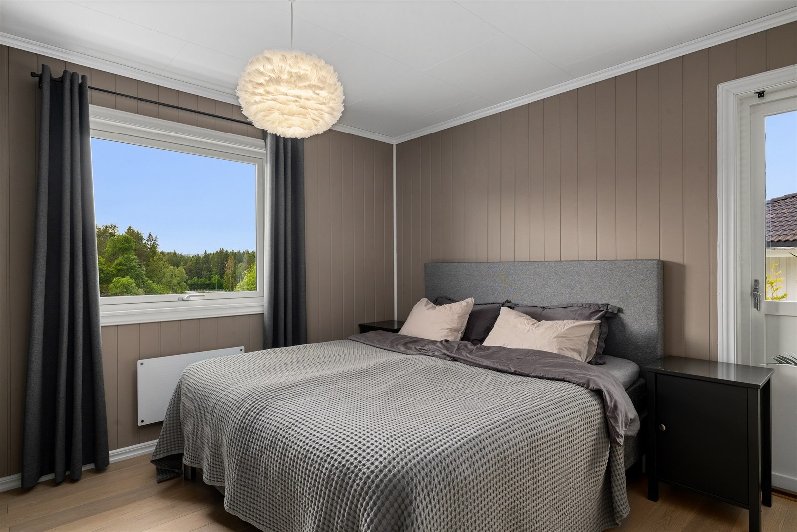 Fint soverom med eikeparkett og beigemalte panelplater. Galleribilde