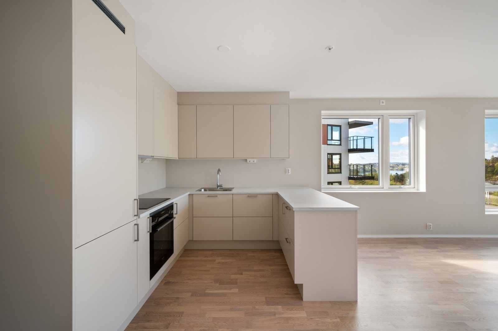 Leiligheten er utstyrt med flott og moderne kjøkken fra Sigdal med beigefronter og hvit laminat benkeplate. Galleribilde