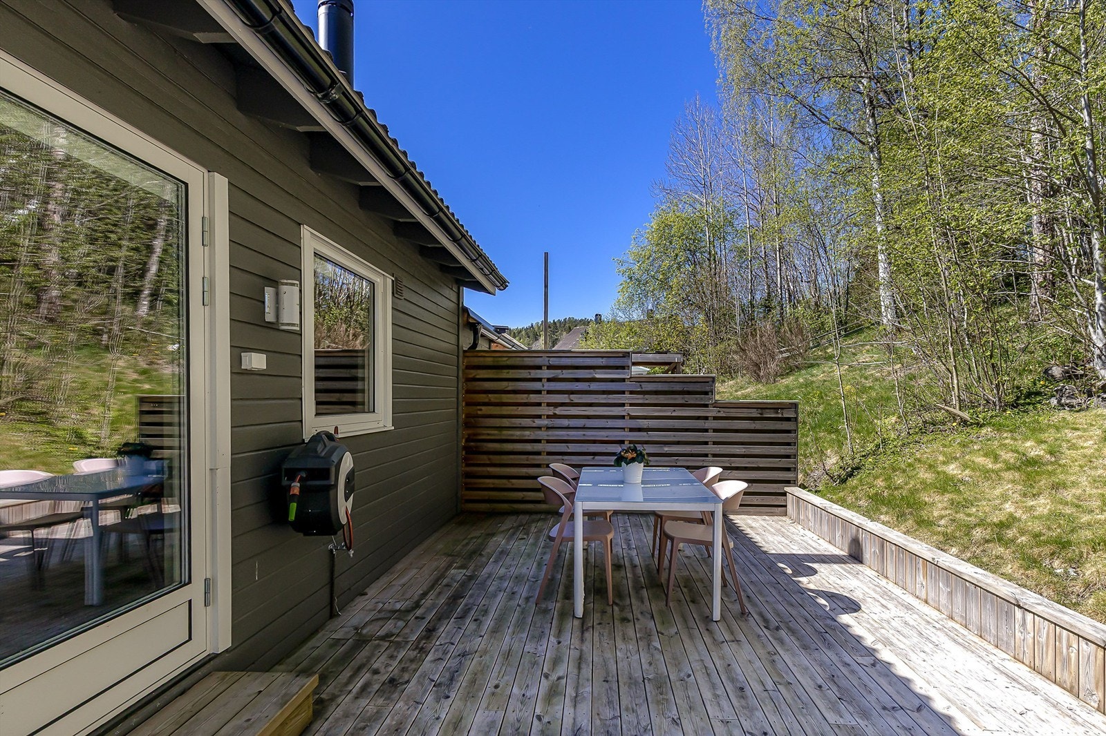 Terrassen kan inndeles i flere soner med spisebord, loungegruppe og grill. Galleribilde