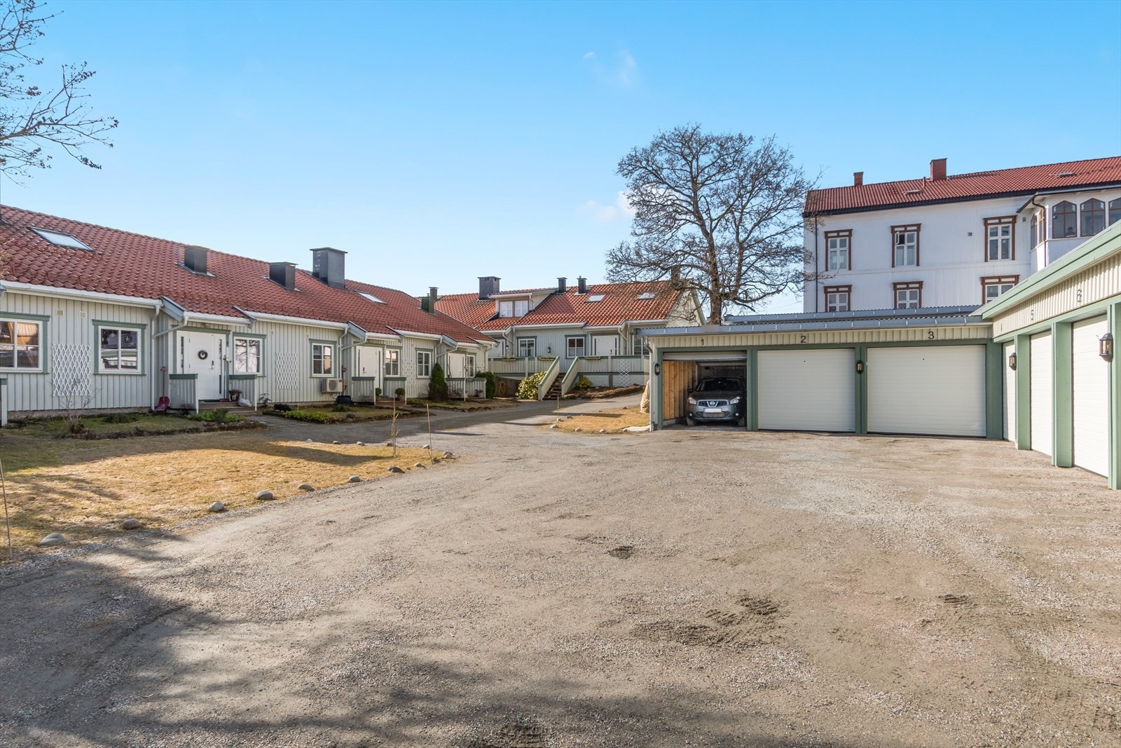 Stor gruset plass med medfølgende garasjeplass i rekke. Galleribilde