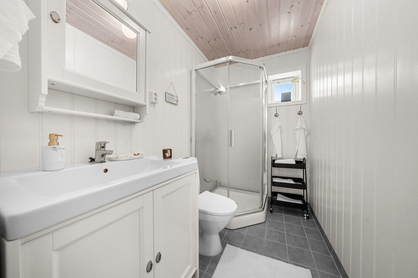 Badet i første etasje har flislagt gulv med varme, dusjkabinett og servantinnredning. Galleribilde