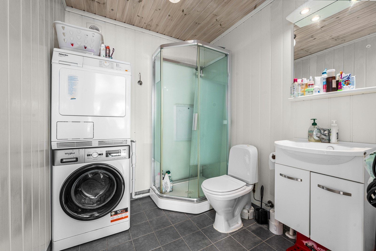 Også badet i leiligheten er utstyrt med flislagt gulv med varme, dusjkabinett og opplegg for vaskemaskin. Galleribilde